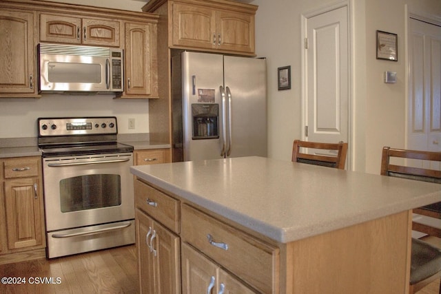 kitchen with a kitchen island, stainless steel appliances, and light hardwood / wood-style flooring