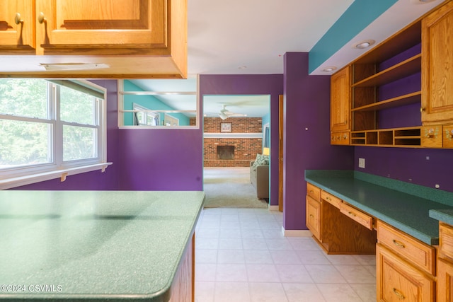 kitchen with a brick fireplace, built in desk, and brick wall