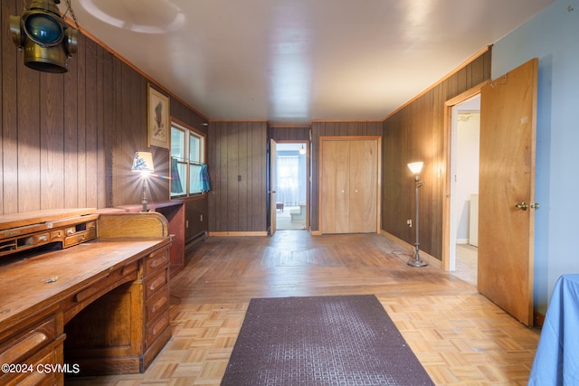 foyer with light parquet floors and wooden walls