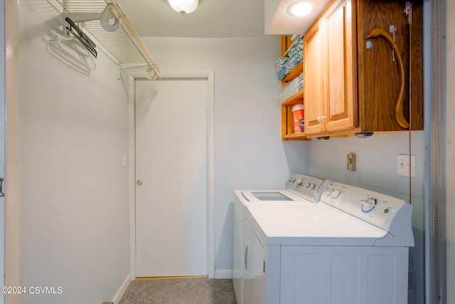 laundry room featuring washing machine and clothes dryer and cabinets