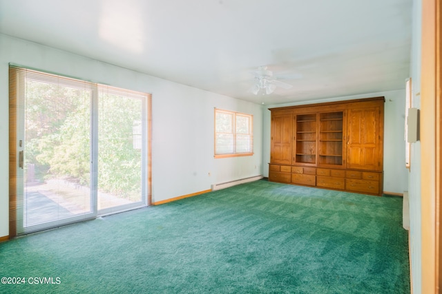 unfurnished bedroom with access to outside, a baseboard heating unit, dark colored carpet, and multiple windows