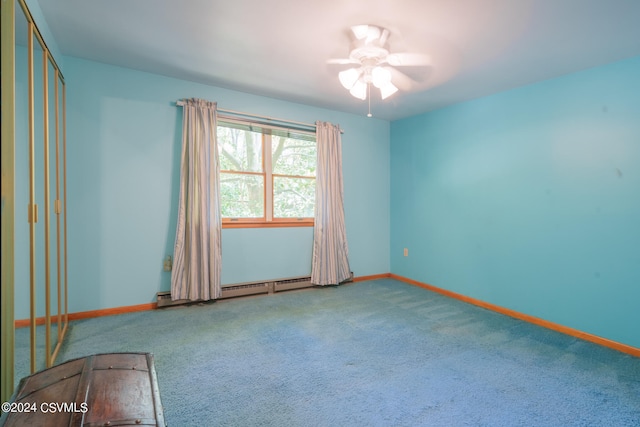 carpeted empty room with ceiling fan and a baseboard heating unit