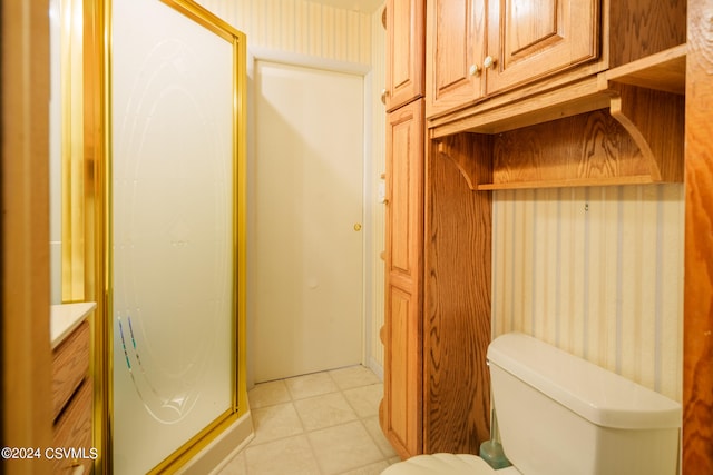 bathroom featuring vanity, a shower with shower door, toilet, and tile patterned flooring