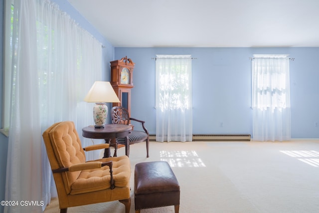 sitting room featuring a baseboard radiator, a wealth of natural light, and carpet floors