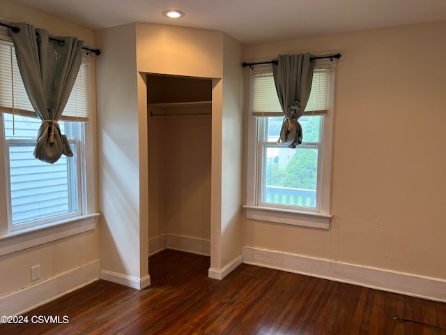 unfurnished bedroom featuring a closet and dark hardwood / wood-style floors