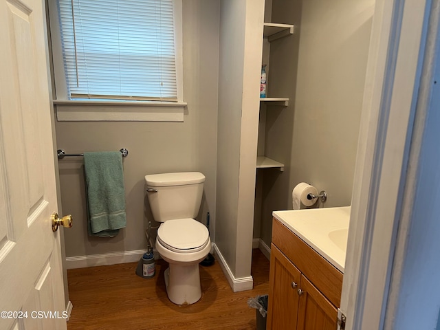 bathroom featuring wood-type flooring, vanity, and toilet