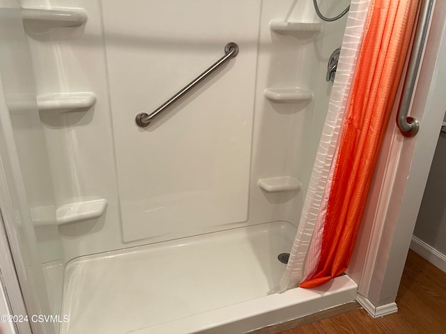 bathroom with walk in shower and wood-type flooring