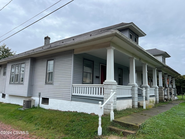 view of home's exterior with a lawn, cooling unit, and a porch