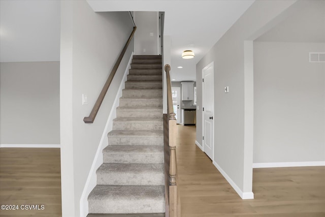 staircase with wood-type flooring