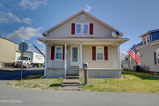 bungalow featuring central AC unit and a front lawn