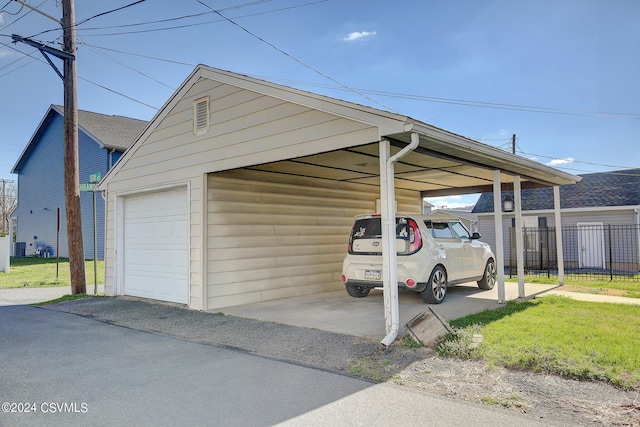 view of car parking with a garage, a lawn, and a carport