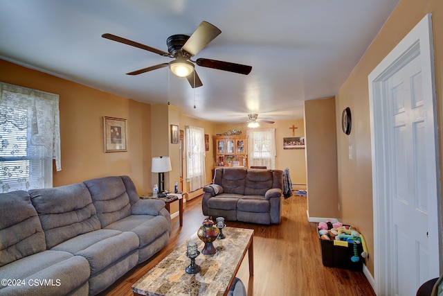 living room with hardwood / wood-style flooring, baseboard heating, ceiling fan, and plenty of natural light