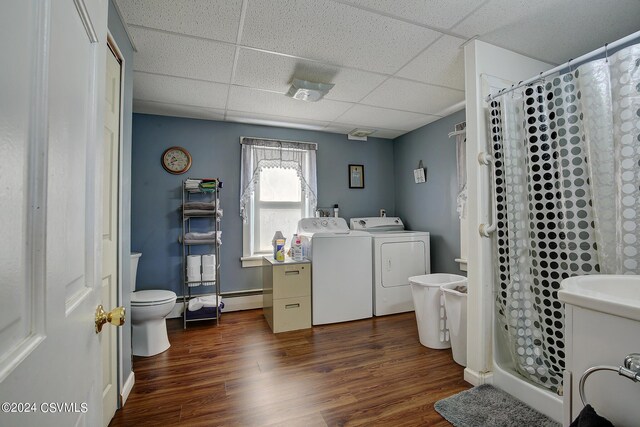 bathroom with vanity, walk in shower, wood-type flooring, toilet, and washing machine and clothes dryer