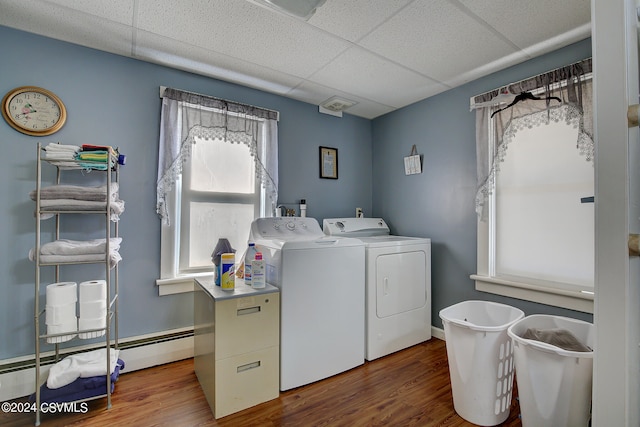 laundry room featuring baseboard heating, washing machine and dryer, and hardwood / wood-style floors