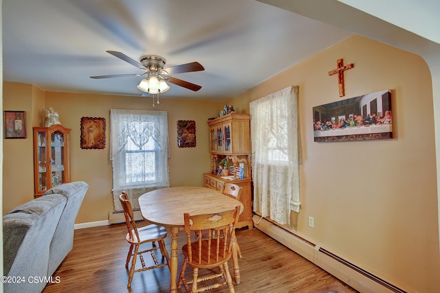 dining space featuring ceiling fan, a baseboard radiator, and light hardwood / wood-style floors