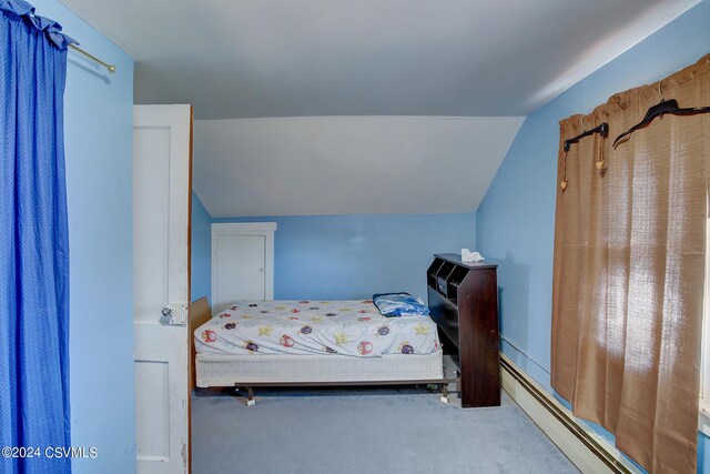 bedroom featuring baseboard heating, vaulted ceiling, and carpet