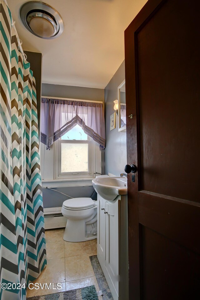 bathroom featuring vanity, toilet, baseboard heating, walk in shower, and tile patterned flooring