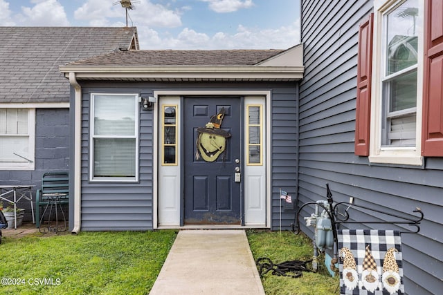 doorway to property with a lawn