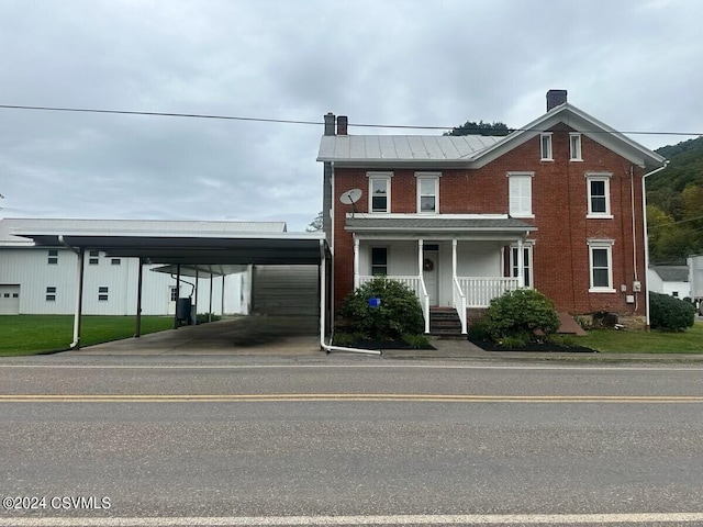 view of front of home with a porch and a carport