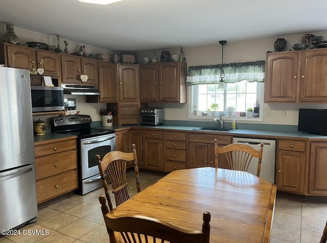 kitchen featuring pendant lighting, light tile patterned flooring, appliances with stainless steel finishes, and sink