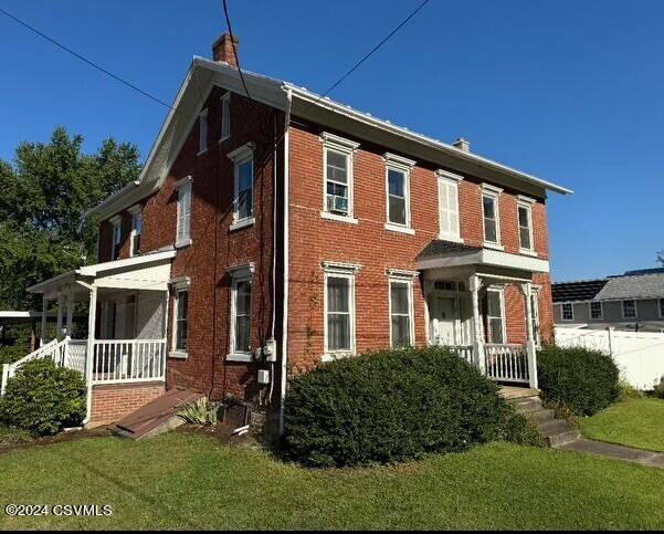 view of front of house with a front yard and a porch