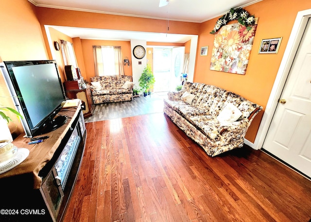 living room featuring wood-type flooring, ornamental molding, and ceiling fan