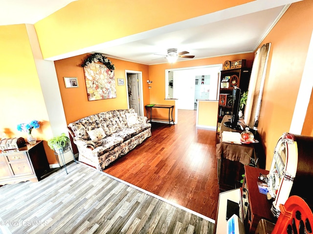 living room with wood-type flooring, ornamental molding, and ceiling fan