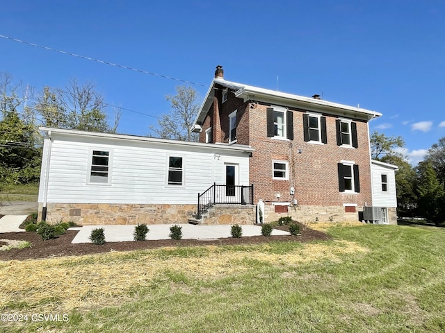 rear view of property with a lawn and central AC unit