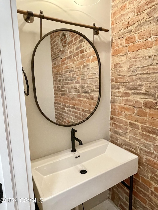 bathroom with brick wall and sink