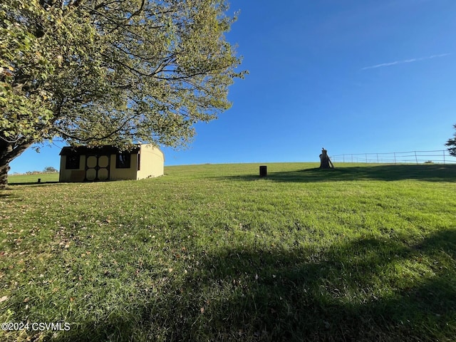 view of yard with a rural view and an outdoor structure