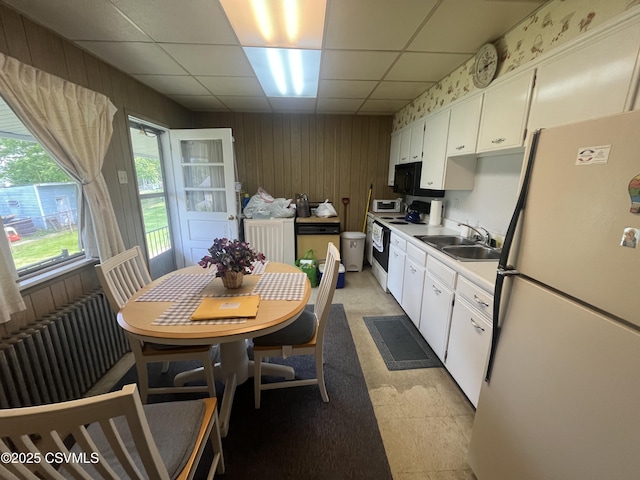 1442 Hemlock St, Coal Township, PA 17866 - kitchen with white appliances, a sink, wooden walls, a paneled ceiling, and light countertops