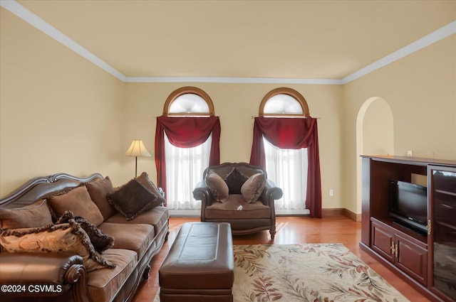 living room with crown molding, baseboards, and wood finished floors