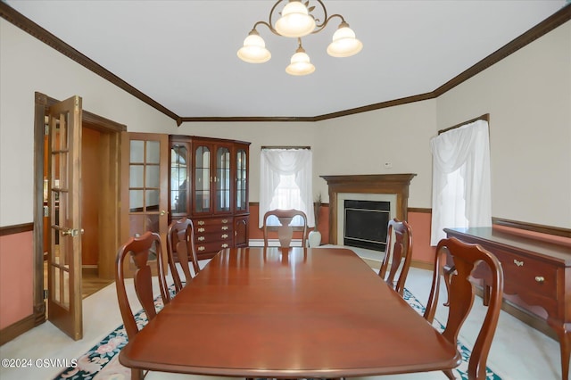 dining room with french doors, an inviting chandelier, a fireplace, and ornamental molding