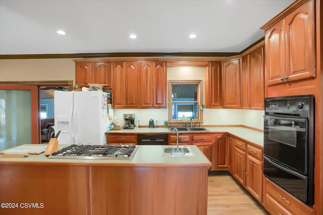 kitchen with a sink, light countertops, a warming drawer, and black appliances