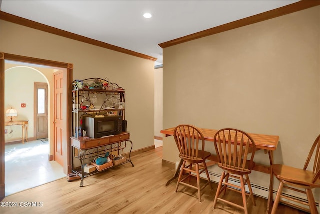 dining space featuring a baseboard heating unit, baseboards, ornamental molding, recessed lighting, and wood finished floors