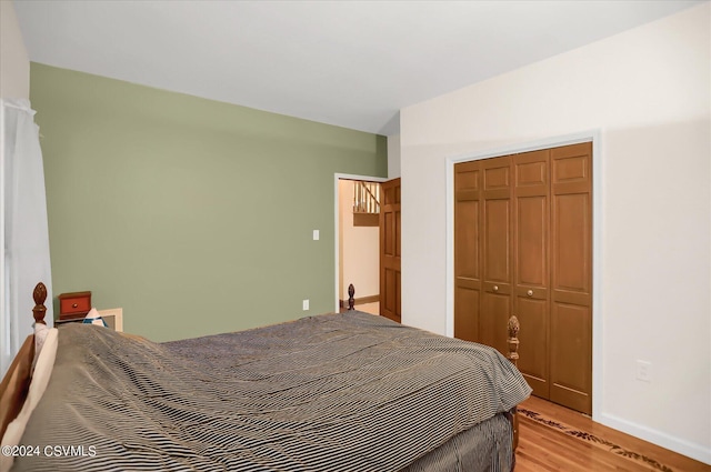 bedroom with light wood-style flooring, a closet, and baseboards