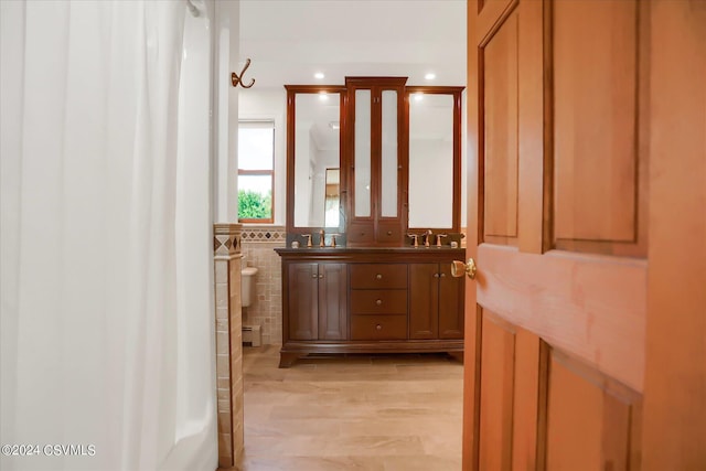 bathroom featuring double vanity, a sink, recessed lighting, and tile walls
