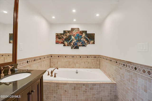 bathroom with tile walls, a garden tub, vanity, and recessed lighting