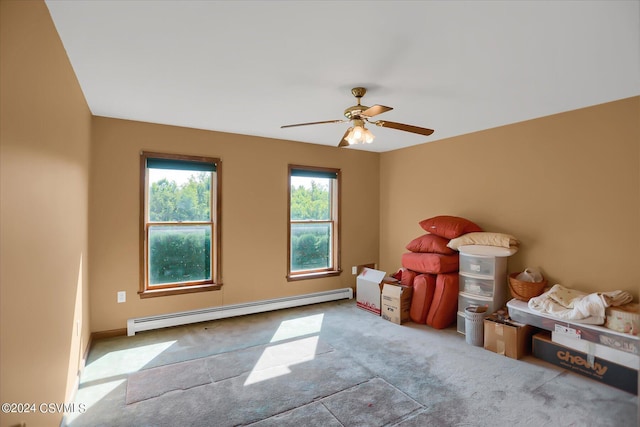 carpeted empty room featuring a baseboard radiator and a ceiling fan