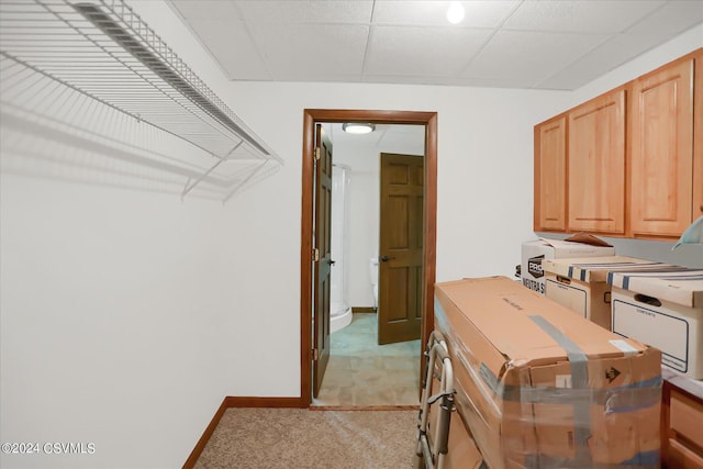 clothes washing area featuring cabinet space, baseboards, washing machine and dryer, and light carpet