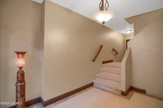 stairs with tile patterned floors and baseboards