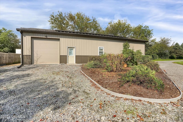 garage with fence and gravel driveway
