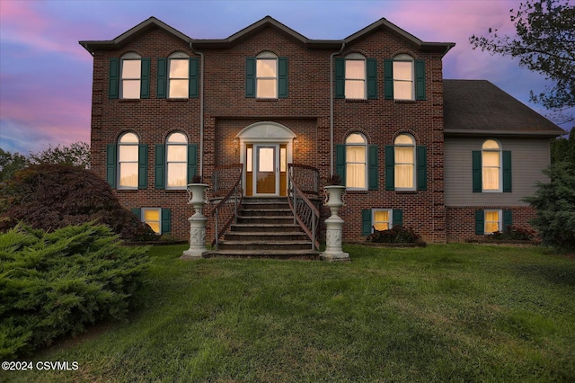 view of front of property with a front yard and brick siding
