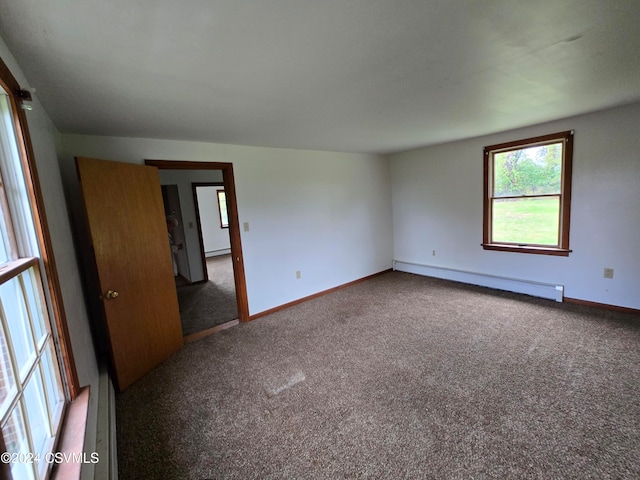 empty room featuring a baseboard radiator and dark colored carpet