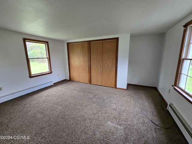 unfurnished bedroom featuring carpet floors, a baseboard radiator, and a closet