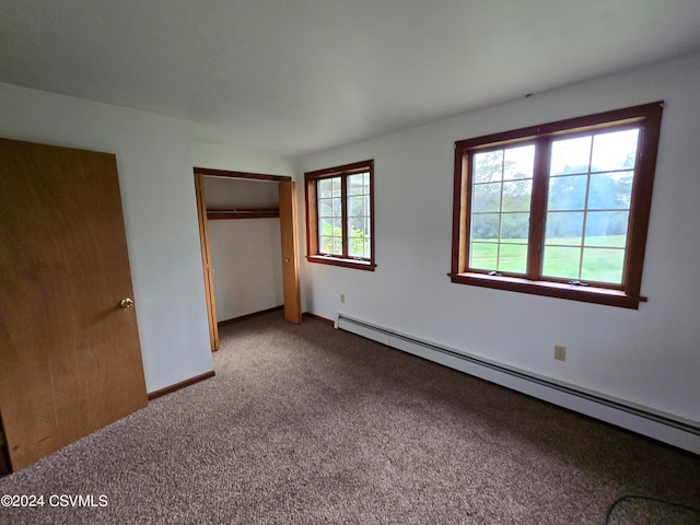 unfurnished bedroom featuring a baseboard radiator, carpet, and a closet