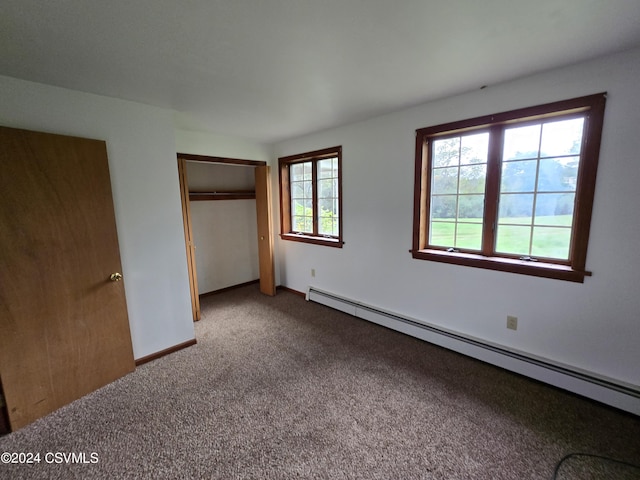 unfurnished bedroom featuring carpet floors, baseboards, baseboard heating, and a closet