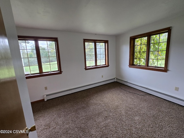 empty room featuring carpet floors, a baseboard radiator, and a wealth of natural light