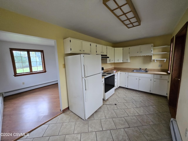 kitchen with a sink, baseboard heating, white appliances, and light countertops