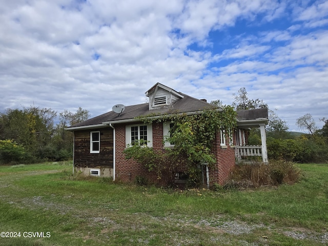 view of property exterior featuring brick siding and a yard